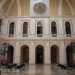 Una serie di bianche arcate segnano il perimetro dellampia sala: le stesse presenti nei finestroni del piano superiore caratterizzate da eleganti balaustre